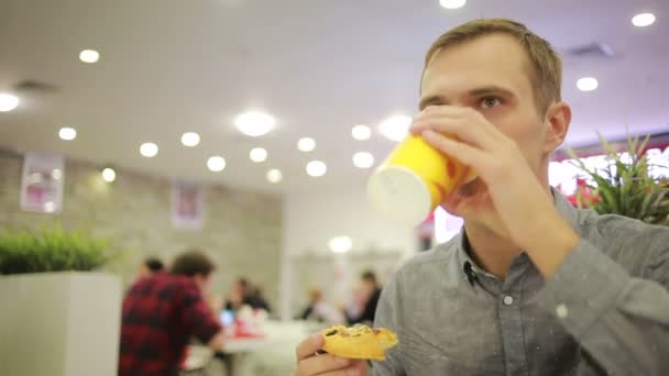 Joven bebiendo un café en el café. comer pizza — Vídeos de Stock