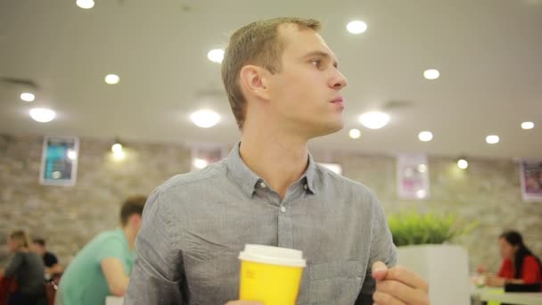 Νεαρός άνδρας πίνοντας ένα καφέ στο καφέ. Τρώγοντας Πίτσα — Αρχείο Βίντεο