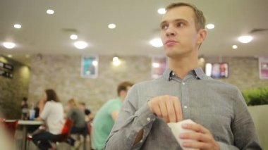 Genç adam café'de bir kahve içme. patates kızartması yemek