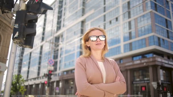 Mujer con gafas de sol de pie en una calle concurrida. mujer, residente de la ciudad . — Vídeo de stock