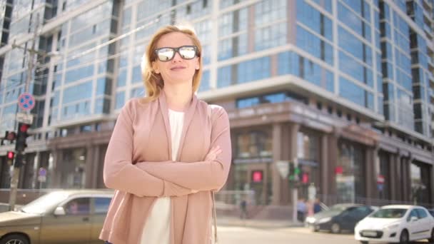 Kobieta w okulary, stojąc na ruchliwej ulicy. Kobieta, miejsce zamieszkania miasto. — Wideo stockowe