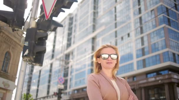 Mujer con gafas de sol de pie en una calle concurrida. mujer, residente de la ciudad . — Vídeos de Stock