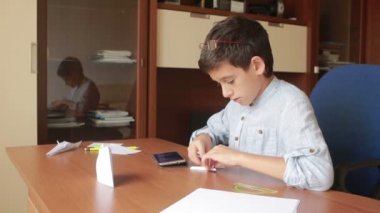 Küçük çocuk kağıt sanat origami üzerinde çizim. hobi el sanatları