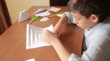 Küçük çocuk kağıt sanat origami üzerinde çizim. hobi el sanatları