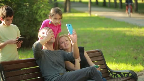 Família indulge. a fazer selfie no parque. rostos virtuais para selfie. Filtros ao vivo — Vídeo de Stock