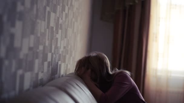 Депрессивная женщина в постели. девушка плачет на диване. острые горы — стоковое видео