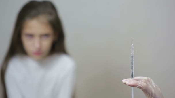 Meisje is bang voor de dokter met een spuit. baby huilt bang injectie — Stockvideo