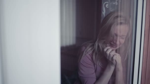 Smutná dívka u okna. Žena, plachet. slzy v schekah — Stock video