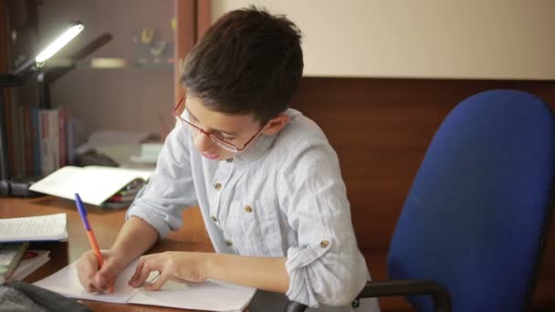 Το παιδί γράφει την εργασία. το παιδί έχει μελετήσει επιστήμη — Αρχείο Βίντεο