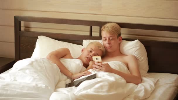 Гомосексуальная пара лежит на кровати. ЛГБТ — стоковое видео
