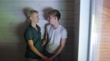 Sarılma ve öpüşme evde gülümseyen gay çift