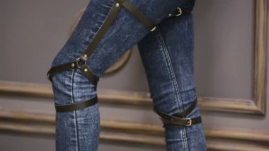Kız kot pantolon deri jartiyer yeni moda trendleri ile. kalça üzerinde kayışlar