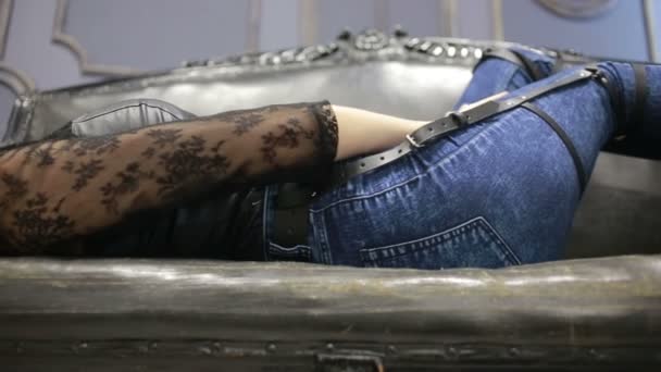 Dívka v džínách s kůží podvazek nové módní trendy. pásy na boky — Stock video