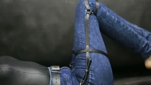 Girl in jeans with leather garter new fashion trends. straps on the hips — Stock Video