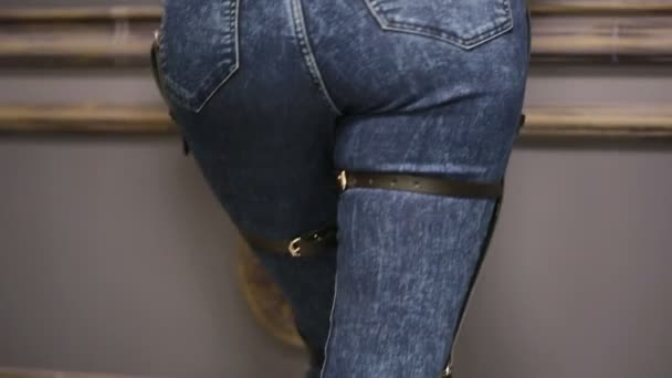 Ragazza in jeans con giarrettiera in pelle nuove tendenze moda. cinghie sui fianchi — Video Stock