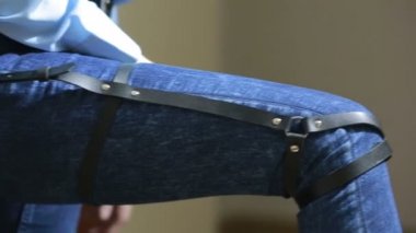 Kız kot pantolon deri jartiyer yeni moda trendleri ile. kalça üzerinde kayışlar