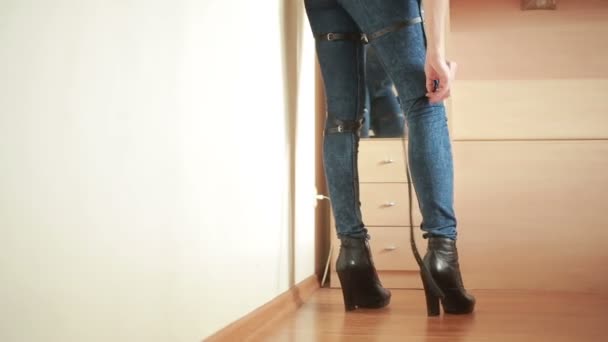 Девушка в джинсах с кожаной подвязкой новые модные тенденции. ремни на бедрах — стоковое видео