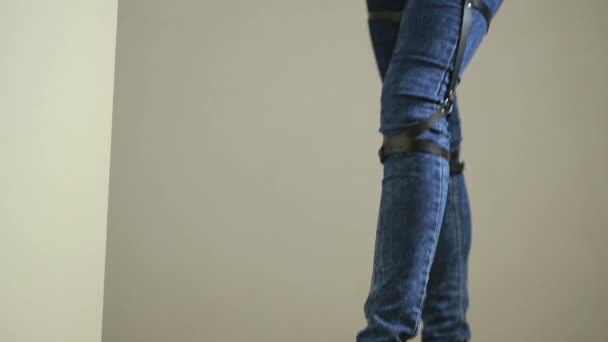 Ragazza in jeans con giarrettiera in pelle nuove tendenze moda. cinghie sui fianchi — Video Stock