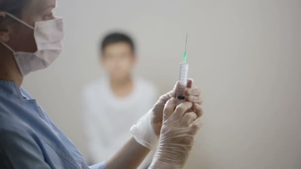 Rapazinho giro com medo da injecção. enfermeira prepara uma seringa — Vídeo de Stock