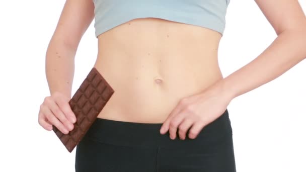 Overweight woman getting dressed wearing jeans and holding chocolate — Stock video