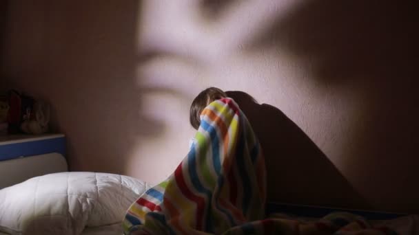 Flicka under täcket på natten som är rädd för spöken. mardrömmar. — Stockvideo