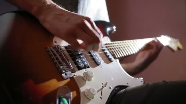 電気ギターを弾く男の手。法を曲げます。石の音楽家 — ストック動画