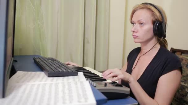 Mulher escreve música no computador. teclado midi piano digital — Vídeo de Stock