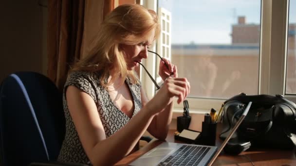 Mulher de negócios sexy peituda trabalhando para um laptop. chupa óculos — Vídeo de Stock
