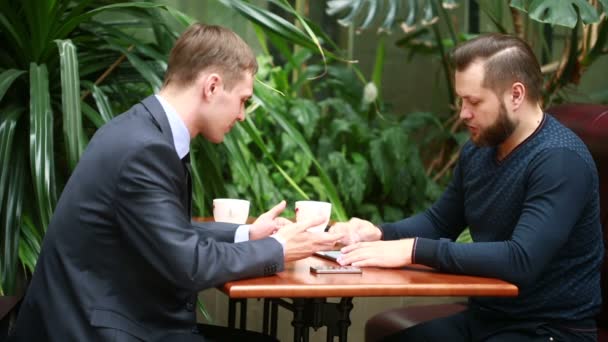 Discussie in een koffieshop door twee zakenlieden — Stockvideo