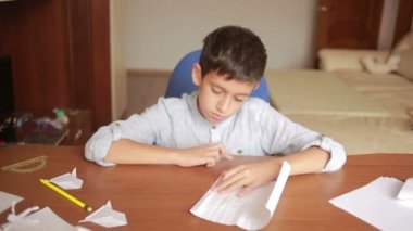 Küçük çocuk kağıt sanat origami üzerinde çizim. hobi el sanatları