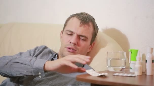 Nemocný muž ležící v posteli utrpení virus s tablety léku. pití pilulka — Stock video