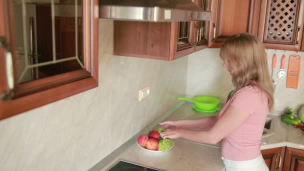 Meisje wast druiven. groenten op de keukentafel. tomaten en kool — Stockvideo