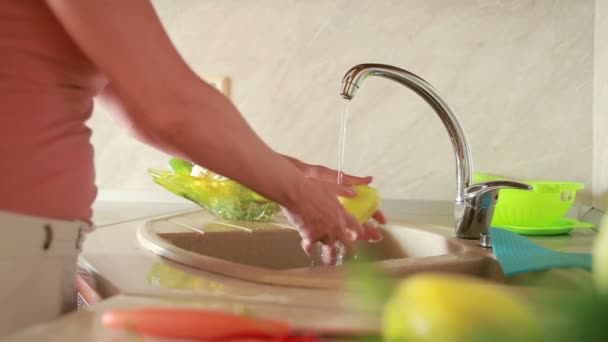 La chica lava uvas. verduras en la mesa de la cocina. tomates y col — Vídeos de Stock