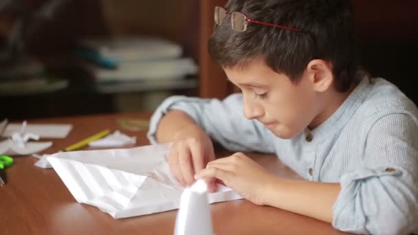 Liten pojke ritning på papper konsten origami. Hobby hantverk — Stockvideo