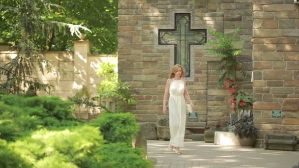 Belle jeune fille en robe debout près de fontaine de pierre vintage . — Video