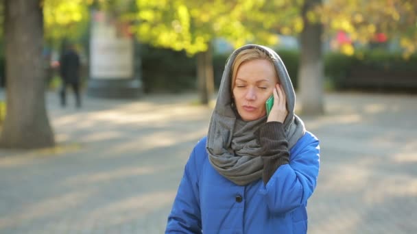 Joven mujer sonriente hablando por teléfono celular en el parque de otoño . — Vídeos de Stock