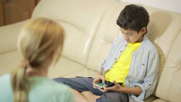 Tonåren son leker med telefonen, mor försöker prata — Stockvideo