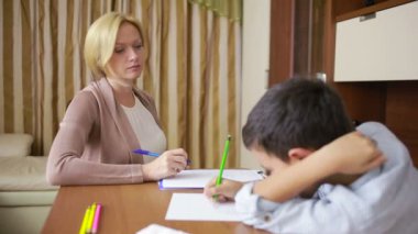 Genç çocuk sessizce oturumu sırasında genç psikolog ile oturuyor..