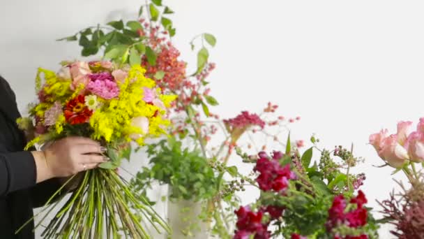 Floristería prepara un ramo de flores para la venta a los clientes — Vídeo de stock