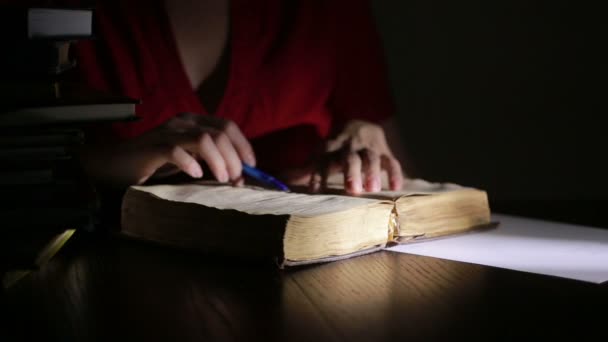 Slimme man laat in de nacht studeren, hij zit aan Bureau- en leesboek — Stockvideo