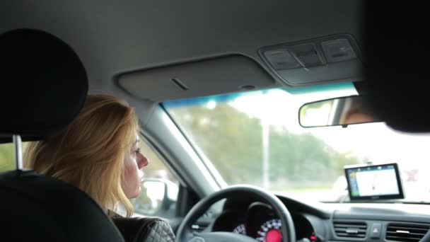 Une femme conduisant une voiture. fille attentive promenades autour de la ville — Video