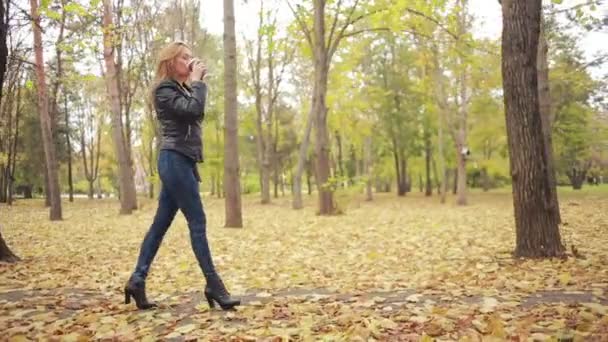 Belle jeune femme dans le parc d'automne. blonde dans une veste en cuir 