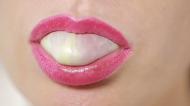 Person doing bubble with chewing gum on bright background — Stock Video