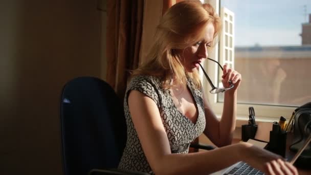 Vollbusige sexy Geschäftsfrau, die für einen Laptop arbeitet. saugt Brille — Stockvideo