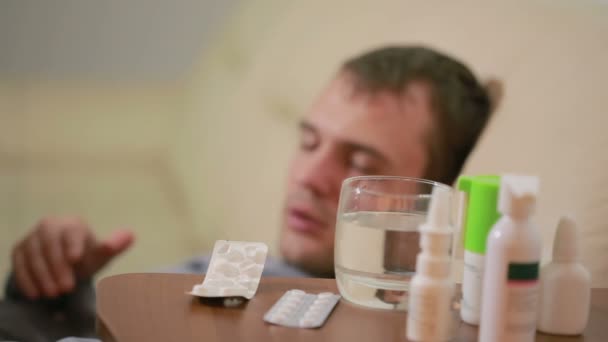 患病男子躺在床上痛苦病毒有成药片剂。喝丸 — 图库视频影像