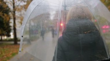 Kız bir şemsiye ile yağmurda. sonbahar kadını sokakta yürürken