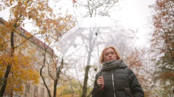 Девушка под дождем с зонтиком. осень женщина, идущая по улице — стоковое видео