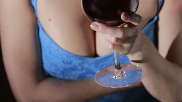 Žena s velkými prsy drží sklenku červeného vína. detail — Stock video