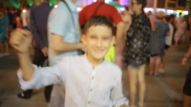 Έφηβος αγόρι χαμογελά στη φωτογραφική μηχανή. νύχτα στο δρόμο. χορεύει, να παίζει ο ανόητος — Αρχείο Βίντεο