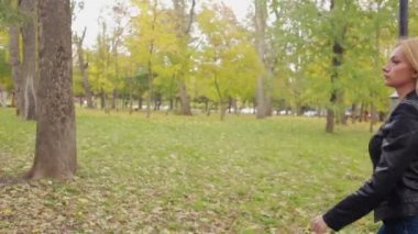 Sonbahar Park güzel ve genç birbayan. deri ceketli sarışın